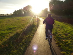 FZ008499 Hans, Machteld and Jenni push biking into sunset.jpg